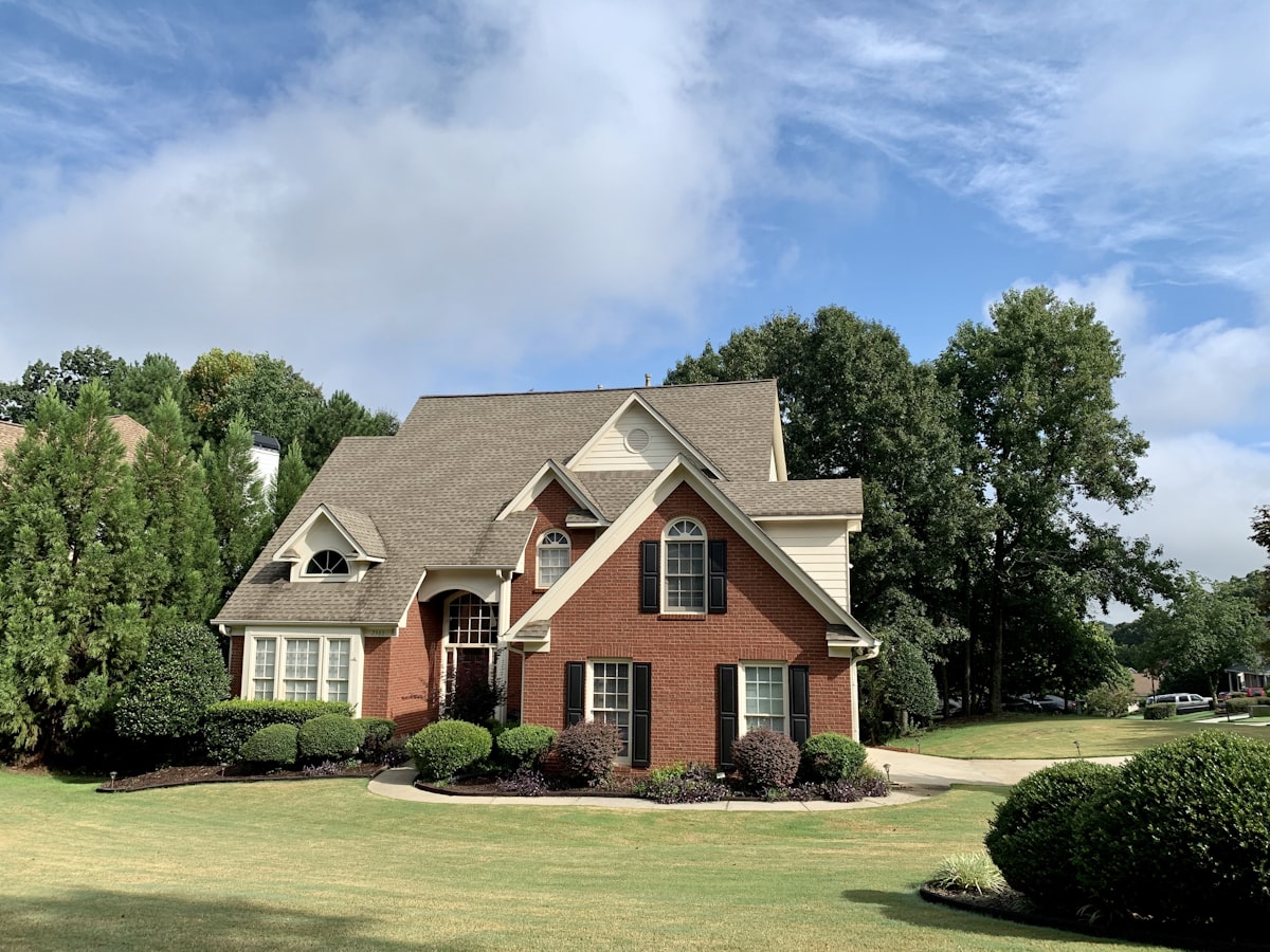 A brick home with a manicured front lawn